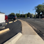 Image of Independence Street before conditions, showing a sidewalk immediately next to a parking lot.